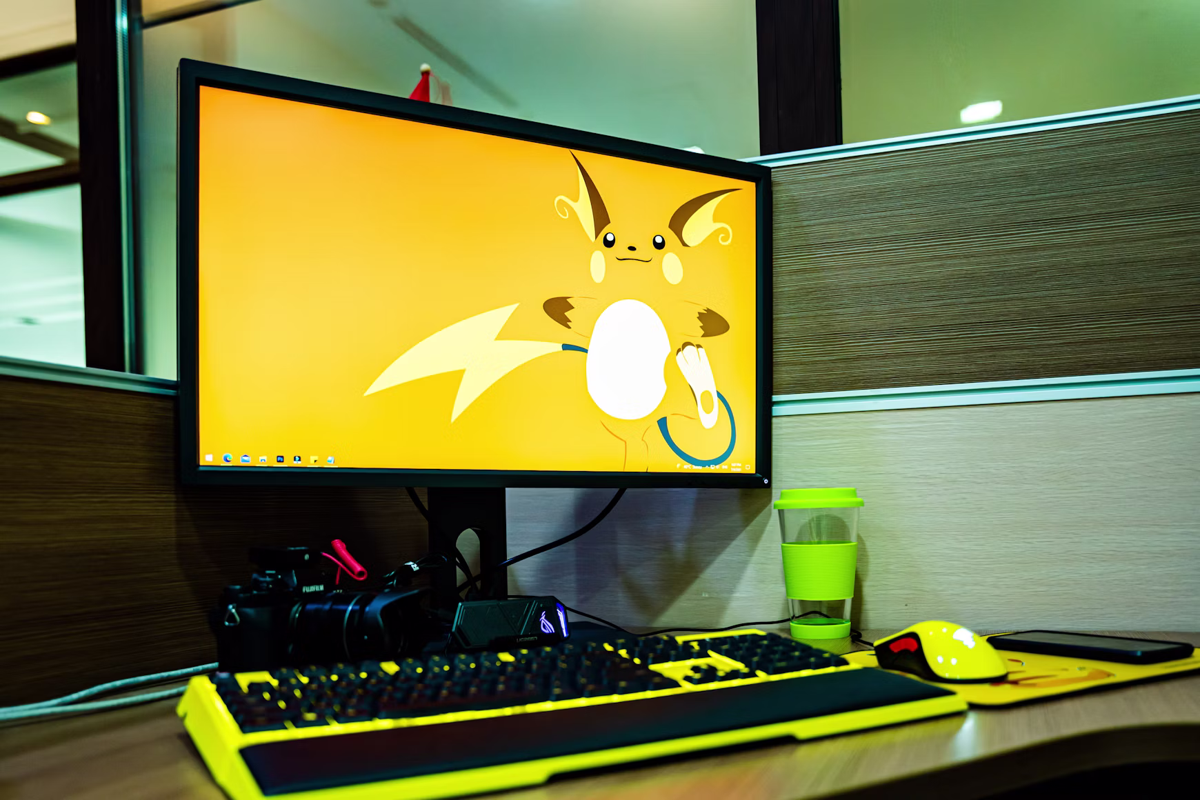 biurko z monitorem, na którym na tapecie jest pokemon