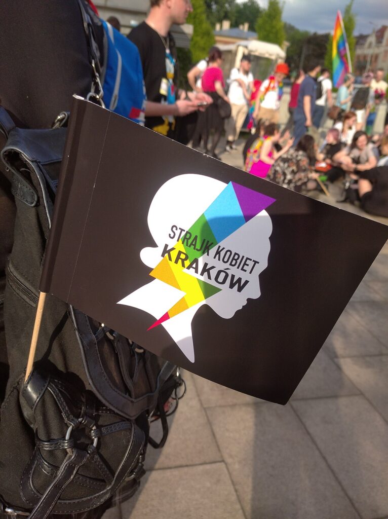 Chorągiewka z logiem Strajku Kobiet niesiona na marszu równości w Krakowie (2022)